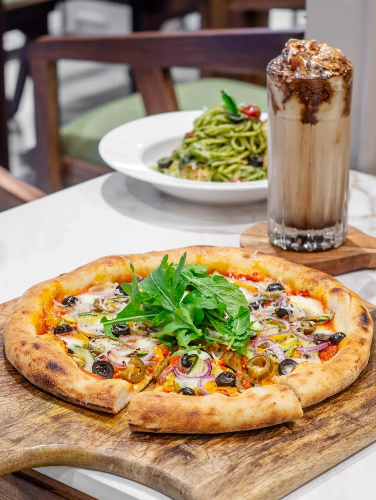 Pizza, pasta and a shake on a table at Brunatos
